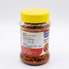 A jar of Srigarhanchi Mango Chutney with a bright yellow lid, showing the red and yellow chutney inside a clear glass container on a white background.